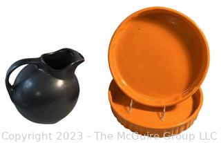 Two (2) Orange Fluted Casserole Dishes and Black Hall Ball Pitcher