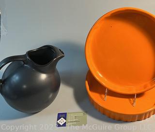 Two (2) Orange Fluted Casserole Dishes and Black Hall Ball Pitcher