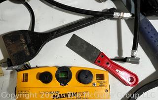 Eclectic Assortment of shop tools including Magnum Laser Level, Masonry Chisel, and 5 pound Metal Sledge 