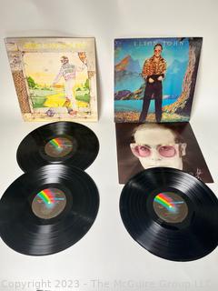 Two (2) Vinyl Record Albums: Elton John, Double Album, "Goodbye Yellow Brick Road", MCA Records 1973. Elton John, "Caribou", MCA Records 1974. Poster insert included.