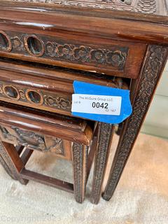 Set of Three (3) Chinoiserie Style Carved Chinese Rosewood Nesting Tables. Each carved with an individual scene that continues around the edge. With top glass inserts.  Largest Table 17"w x 12"d x 22"t