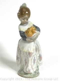 Lladro “Valencia Girl” #4841” Glazed Porcelain Figurine of a Girl Holding Oranges Made in Spain.  7" tall