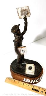 Cast Bronze of Newsboy Signed by Artist Jim McCartin (1919 - 1999) on Wood Base.  13" tall. 