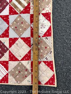 Vintage Hand Stitched Flour Sack Quilt in the Hour Glass Chain Pattern. Some staining. Measures 83" x 77".