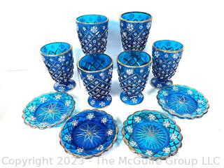 Set of Blue Depression Glass Plates and Goblets Decorated With Flowers And Gold