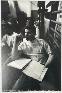 Vintage photos of the early Philadelphia Eagles football coaches and players reviewing plays and video.