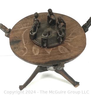 Carved Wood Tripod Table From Zimbabwe with African Wooden Disc With Six Men Seated.