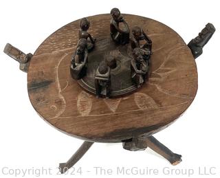 Carved Wood Tripod Table From Zimbabwe with African Wooden Disc With Six Men Seated.