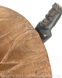 Carved Wood Tripod Table From Zimbabwe with African Wooden Disc With Six Men Seated.