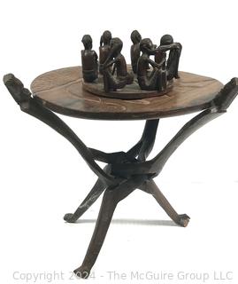 Carved Wood Tripod Table From Zimbabwe with African Wooden Disc With Six Men Seated.