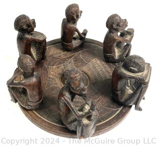 Carved Wood Tripod Table From Zimbabwe with African Wooden Disc With Six Men Seated.