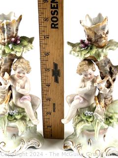 Pair of Cherub Arnart Porcelain Hand Painted Rococo Style Candlestick Holders.  8 1/2" tall.