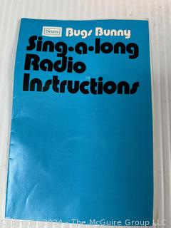 Character Toys Including Sears Bugs Bunny Sing-Along Novelty Radio, Looney Tunes Bugs Bunny Alarm Clock 1974, and Corgi Magic Roundabout Musical Carousel.