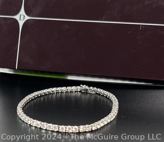 DeBeers Classic Eternity Line Round Brilliant Diamond Tennis Bracelet. It is composed of a single row of round brilliant-cut diamonds with a combined weight of approximately 5.79 carats. Each diamond is prong-set in 18K white gold.  7 ½” (19 cm) long.  Check retail price on DeBeers website.