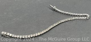 DeBeers Classic Eternity Line Round Brilliant Diamond Tennis Bracelet. It is composed of a single row of round brilliant-cut diamonds with a combined weight of approximately 5.79 carats. Each diamond is prong-set in 18K white gold.  7 ½” (19 cm) long.  Check retail price on DeBeers website.