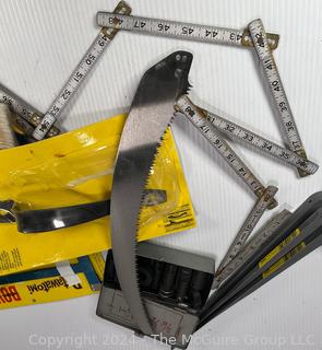 Assortedment of Hand Tools including Metal Folding Rule, New Pole Saw Blade, Adjustable Circular Clamps and Metal Brackets