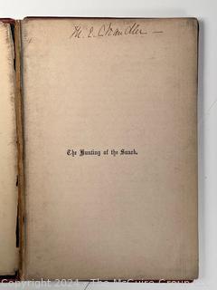 "The Hunting of the Snark: An Agony in Eight Fits" by Lewis Carroll. 

London: MacMillan and Co., 1876. xi,(3),83 pp. 12 mo. Dark Red Front and Rear Boards with Gilt Pictorial Illustrations by Henry Holiday. All edges gilt. Original black endpapers. Printed in London by R. Clay Sons & Taylor. Half title. One old ownership signature. Original plate tissue on Title Page. Last unnumbered leaf contains advertisements for Carrol's other works. A First Edition, this Issue Contains "Baker" for "Butcher" on p83. A fantastical poem involving a strange crew of tradesmen and a beaver as they set off on a journey to find "the Snark". 

1876 First Edition, 17th Printing of 1,000 {Description Updated 9/19/24 at 4:27pm ET}