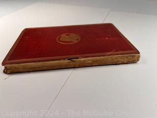 "The Hunting of the Snark: An Agony in Eight Fits" by Lewis Carroll. 

London: MacMillan and Co., 1876. xi,(3),83 pp. 12 mo. Dark Red Front and Rear Boards with Gilt Pictorial Illustrations by Henry Holiday. All edges gilt. Original black endpapers. Printed in London by R. Clay Sons & Taylor. Half title. One old ownership signature. Original plate tissue on Title Page. Last unnumbered leaf contains advertisements for Carrol's other works. A First Edition, this Issue Contains "Baker" for "Butcher" on p83. A fantastical poem involving a strange crew of tradesmen and a beaver as they set off on a journey to find "the Snark". 

1876 First Edition, 17th Printing of 1,000 {Description Updated 9/19/24 at 4:27pm ET}