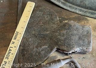 Grouping of Bench Tools Including Sickles, Hack Saw, Horse Bits, Hand Drill Brace and Large Axe Head  