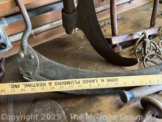 Grouping of Bench Tools Including Sickles, Hack Saw, Horse Bits, Hand Drill Brace and Large Axe Head  