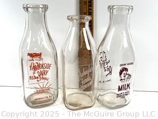 Group of three (3) antique glass milk bottles: various brands
