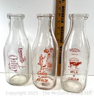 Group of three (3) antique glass milk bottles: various brands