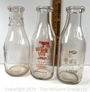 Group of three (3) antique glass milk bottles: various brands