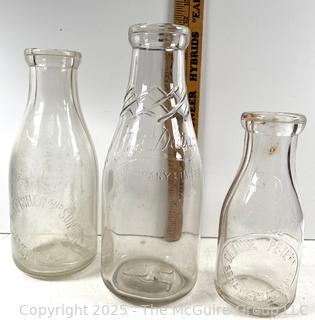 Group of three (3) antique glass milk bottles: various brands