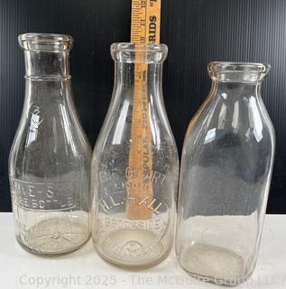 Group of three (3) antique glass milk bottles: various brands