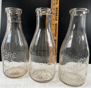 Group of three (3) antique glass milk bottles: various brands