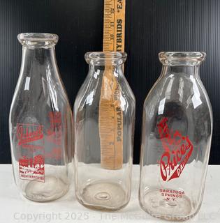 Group of three (3) antique glass milk bottles: various brands