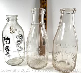 Group of three (3) antique glass milk bottles: various brands