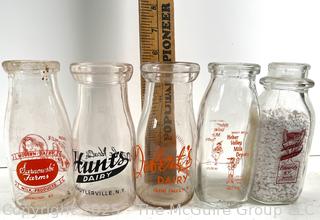 Group of five (5) antique glass milk pint bottles: various brands