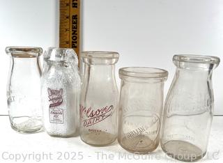 Group of five (5) antique glass pint milk bottles: various brands