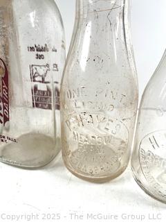 Group of five (5) antique glass milk bottles: various brands
