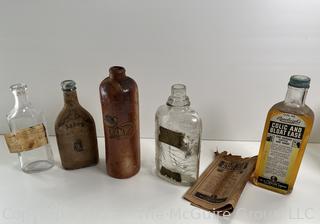 Group of antique glass bottles: various brands some with labels 
