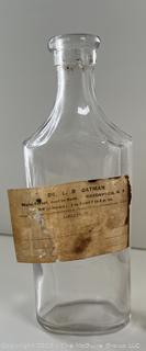 Group of antique glass bottles: various brands some with labels 