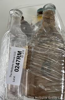 Group of antique glass bottles: various brands some with labels 