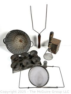 Assorted antique kitchen tools: colander, muffin tray, masher, tin, etc