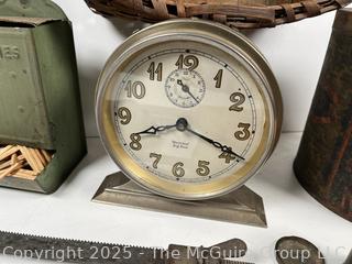 ????????  Eclectic grouping: metal tray; coffee tin; Hanging match holder; hack saw; alarm clock and wicker basket 