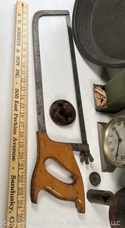 ????????  Eclectic grouping: metal tray; coffee tin; Hanging match holder; hack saw; alarm clock and wicker basket 