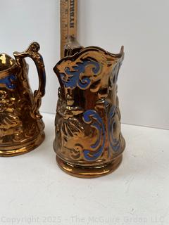 Two (2) Porcelain Lusterware Pitchers<br>

<br><br>

Removal Options:<br><br> Sat (Nov 8) & Sun (Nov 9) 11-3pm, 56 Scotch Hill Rd., Cambridge NY 12816<br><br>

Sat (Nov 15) 12-2pm, TMG Warehouse, 2800 Juniper St., Fairfax, VA 22031<br><br>

Request Shipping (david@themcguiregroupllc.com)