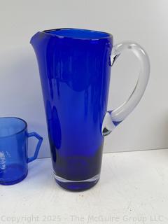 Cobalt Blue Glassware Including Hazel-Atlas Shirley Temple Plate and Mug and Bar Pitcher<br>

<br><br>

Removal Options:<br><br> Sat (Nov 8) & Sun (Nov 9) 11-3pm, 56 Scotch Hill Rd., Cambridge NY 12816<br><br>

Sat (Nov 15) 12-2pm, TMG Warehouse, 2800 Juniper St., Fairfax, VA 22031<br><br>

Request Shipping (david@themcguiregroupllc.com)