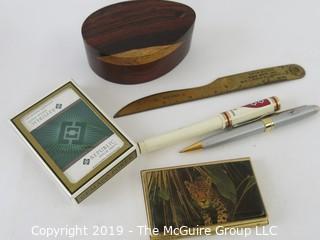 WYSIWYG: Desktop items: wood oval box, playing cards, letter opener, Harvard pen, Jaguar card case, pen