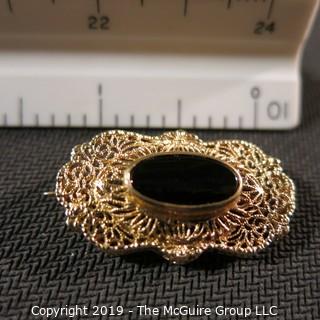 Jewelry:  Antique design, oval 14K yellow gold filigree with bezel set black onyx brooch, 32 x 18 mm.  Like new. 4.3 grams total weight; (TMG 756)