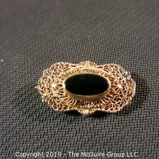 Jewelry:  Antique design, oval 14K yellow gold filigree with bezel set black onyx brooch, 32 x 18 mm.  Like new. 4.3 grams total weight; (TMG 756)