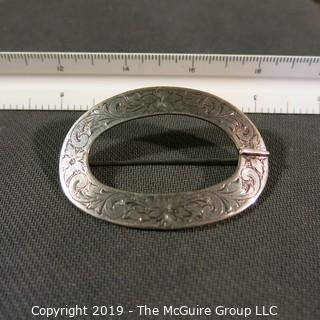 Jewelry: 2.75 x 2 in. sterling oval buckle style brooch and engraved with 4 flowers and acanthus leaves.  Slight damage on right side.