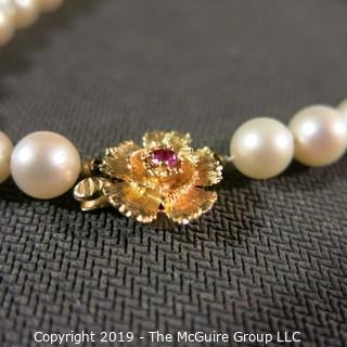 Jewelry: Lovely, knotted 15 in. strand of 7mm, white, Akoya pearls with 14K Yellow gold floral clasp with safety, and center 2.5 mm ruby. (TMG 757)