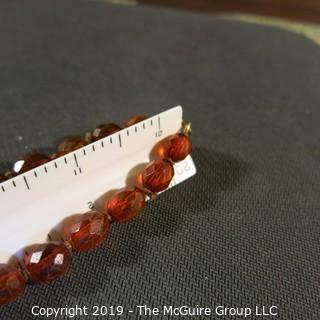 Jewelry: Necklace of 51 graduated and faceted Amber beads, 9 x 7 – 22 x 18mm, knotted – moderate wear.