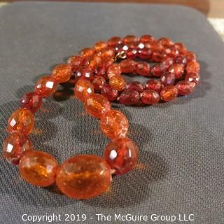 Jewelry: Necklace of 51 graduated and faceted Amber beads, 9 x 7 – 22 x 18mm, knotted – moderate wear.